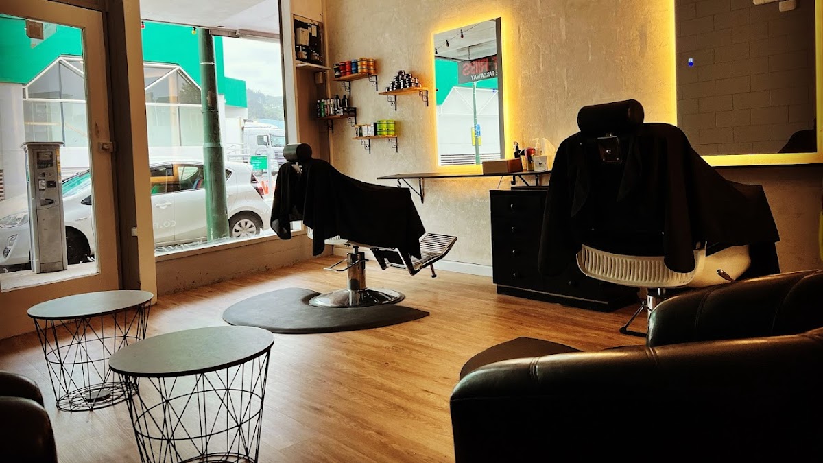 Inside The Godfather Barber Shop with backlit mirrors and black barber chairs
