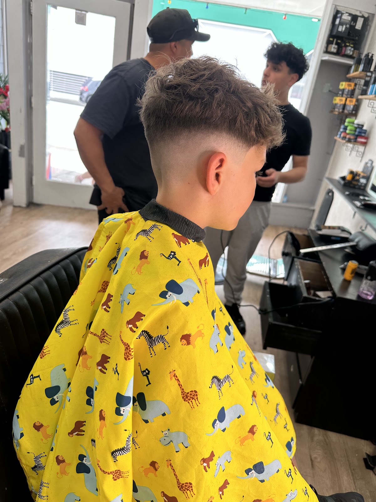 Kids haircut with both barbers working in the background